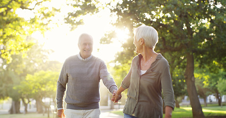 Image showing Walking, holding hands and a senior couple outdoor at a park with a love, care and support. Elderly man and woman in nature to follow on a walk, quality time and happy marriage or healthy retirement