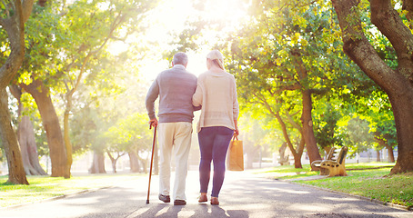 Image showing Senior man, daughter and cane outdoor in a park while walking together for support, love and care. Elderly father and a woman walk for a healthy retirement, life insurance and family time in nature