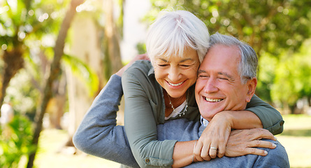 Image showing Love, hugging and elderly couple in a garden together with care, happiness and romance. Smile, nature and senior man and woman in retirement embracing, laughing and sitting in an outdoor green park.