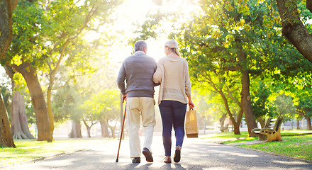 Image showing Back, woman and senior father in a park, walking and care with fresh air, bonding and loving together. Family, male parent and female adult outdoor, street and peace with routine, wellness and break