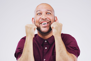 Image showing Celebration, excited and portrait of a man in a studio with a surprise, wow or omg facial expression. Happy, smile and face of male model with fist pump to celebrate an achievement by gray background