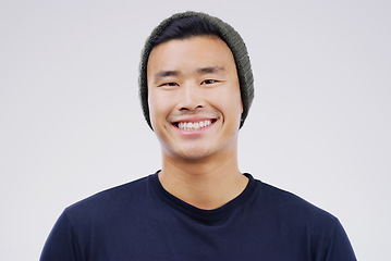Image showing Face portrait, smile and Asian man in beanie in studio isolated on a white background. Happy, handsome and male person from Japan with confidence, fashion and stylish aesthetic for positive mindset.