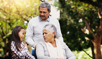 Image showing Grandparents, park and old woman in wheelchair together with her husband and granddaughter. Person with a disability, family or kids and girl child bonding with her senior relatives in natural garden