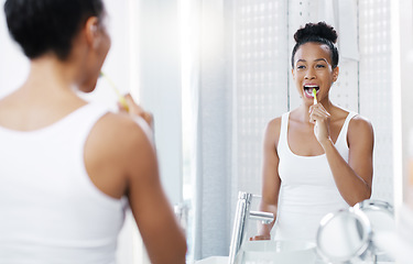Image showing Woman brushing teeth in bathroom, mirror and oral hygiene, morning routine with toothbrush and dental health. Female person at home, grooming and self care, clean mouth with toothpaste and wellness