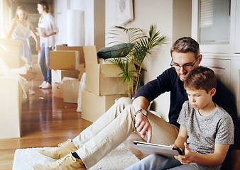 Image showing Man, boy and tablet, playing games and relax, break from unpacking and moving into new house. Father, son and wireless tech with property, real estate and rest with video game online and bonding