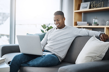 Image showing Black man relax on couch with laptop, streaming online in living room and subscription service with internet. Technology, connectivity and happy male person chill at home watching tv show or film