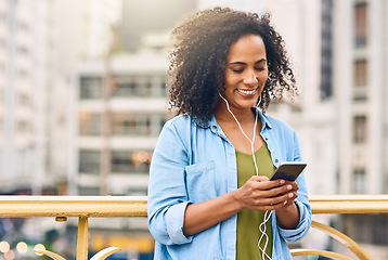 Image showing Phone, music and woman in city with happiness listening to track, audio and song in urban town. Traveling, online and happy African female person streaming radio for relax, chill and peace on weekend