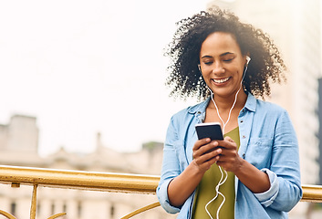 Image showing Music, happy and woman in city with phone for happiness listening to track, audio and song in urban town. Traveling, mockup space and African female person smile streaming radio for relax on weekend