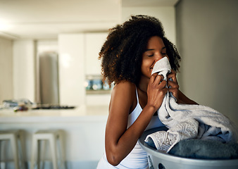 Image showing Laundry smell, African woman and home cleaning chores with happiness and calm. Smile, fresh clothes and happy with housekeeping of a black female person in a house feeling relax in the morning