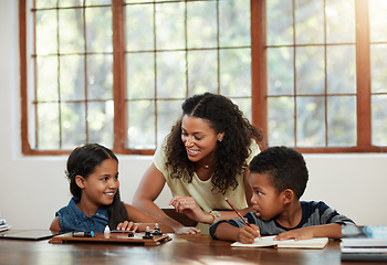 Image showing Education, children and mother with girl, boy and doing homework or learning on a dining room table or parent and together. Family, home and school with mom teaching her daughter or son and indoors