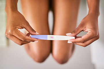 Image showing Health, hands and closeup of a positive pregnancy test by a woman in the bathroom of her home. Maternity, motherhood and zoom of a female person with a pregnant stick with results in her modern house