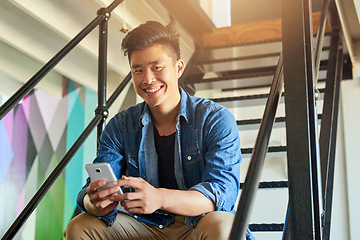 Image showing Asian man, office stairs and texting with phone in portrait with chat, smile and social network app. Young japanese creative, web design startup and relax on steps in workplace, contact and cellphone