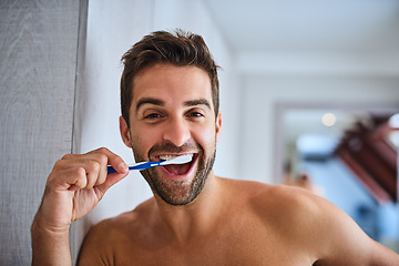 Image showing Portrait, toothbrush and face of happy man brushing teeth in home for dental wellness, healthy habit and gums. Excited guy cleaning mouth for fresh breath, oral hygiene or morning routine in bathroom