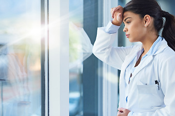 Image showing Stress, thinking and doctor woman by window with worry, anxiety and tired with headache in clinic. Healthcare, mental health and sad female health worker stressed, depressed and burnout in hospital
