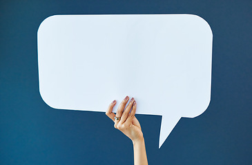 Image showing Hand, speech bubble and woman in studio with banner, news or announcement on blue background. Mockup, poster and girl fingers with billboard for social media, advertising or opinion, vote or space