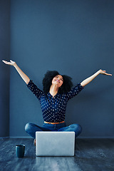 Image showing Laptop, success and businesswoman in celebration on the floor by a blue wall with a mug. Happy, smile and excited professional female employee with an achievement or goals to celebrate with computer.