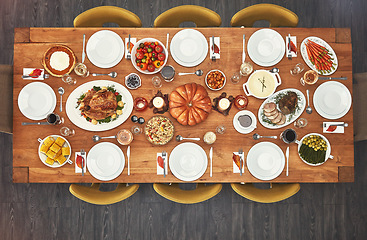 Image showing Dinner, event and top view of Christmas lunch with food on a table from above of a home dining room for celebration. Chicken, party and holiday or vacation vegetables, meat and salad for a birthday