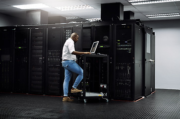 Image showing IT support, black man or coding on computer in server room for big data, network glitch or digital website. Code, fixing or technician typing on laptop testing UX, programming or software development