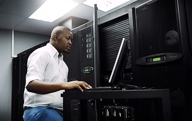 Image showing Engineer, black man or coding on laptop in server room for big data, network glitch or digital website. Code, IT support or technician typing on computer testing, programming or software development