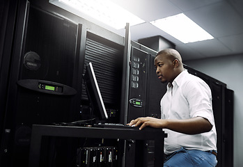 Image showing IT support, black man or coding on laptop in server room for big data, network glitch or digital website. Code, fixing or technician typing on computer testing UX, programming or software development