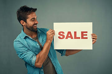 Image showing Happy man, hands and sale sign for advertising, marketing or branding against a grey studio background. Male person or realtor holding board or poster with smile for sales or market advertisement