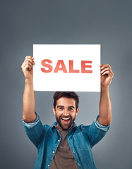 Image showing Happy man, hands and sale sign for advertising, branding or marketing against a grey studio background. Excited male person, surprise holding poster with smile for sales, discount or advertisement