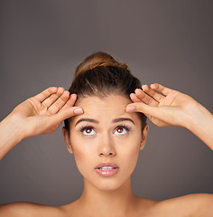 Image showing Stress, touching and a woman with face wrinkles isolated on a dark background in a studio. Concern, anxiety and a young girl frustrated with skincare, filler and a facial beauty cosmetics mistake