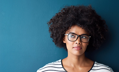 Image showing Optometry, thinking and woman with spectacles in a studio with daydreaming, pensive or idea face expression. Optical, vision and African female model with glasses by blue background with mockup.