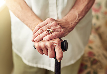 Image showing Hands, walking stick and closeup with senior woman, injury and disabled with balance in retirement in house. Cane, elderly lady and person with disability, support or recovery in home with lens flare