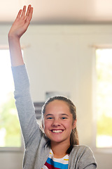 Image showing Question, school and hand of girl in classroom for answer in lesson, learning or education development. Happy portrait, knowledge and young student with hands raised for asking, feedback or questions