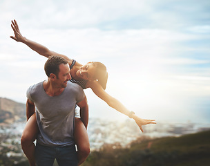 Image showing Travel, happy couple with piggyback ride and mountain outdoors with lens flare. Sunshine or mockup space, nature adventure or freedom and people playing on holiday break or summer vacation together.