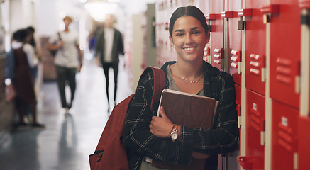 Image showing Portrait, education and books with a student girl by her locker in the hallway of her school. Learning, university and scholarship with a college pupil holding a notebook for studying knowledge