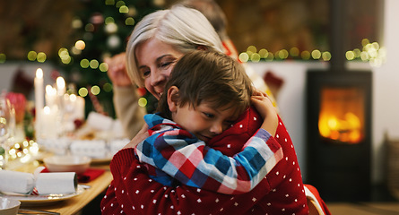 Image showing Christmas, love and a grandma hugging her grandchild in the home during the festive season together. Family, children or holiday with a young boy and senior woman in a house to hug while bonding