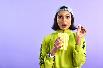 Image showing Shocked, wow and woman with popcorn for a movie or streaming service or cinema and in studio against a purple background. Video, entertainment and film or television or omg and box snack on mock up