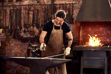 Image showing Worker, blacksmith and metal forge in workshop and manual working on hot steel with hammer, fire and sparks. Man, welding job or iron tools manufacturing and expert, trade and dark workspace