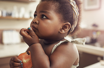 Image showing Black child, tomato and eating baby in a home kitchen with food and fruit at breakfast. African girl, nutrition and youth in a house with hungry kid feeling relax with natural, healthy snack for kids