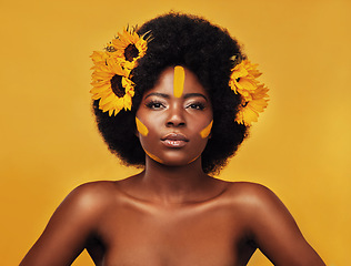 Image showing Makeup, sunflower and glow with portrait of black woman in studio for beauty, hair or spring. Natural, cosmetic and floral with face of model on yellow background for art, self love or confidence