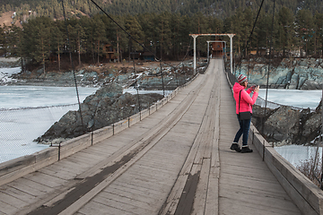 Image showing Happy woman taking photos on the bridge