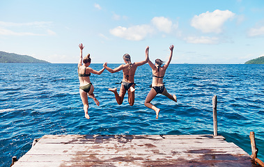 Image showing Back, group and women on a pier, jump and beach with vacation, summer getaway or relax. Female people, girls or friends with water, ocean and sea with holiday, lake and travel with freedom and energy