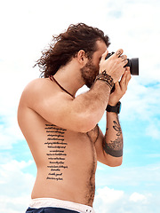 Image showing Man, photographer and camera with blue sky and clouds in summer for photo or picture in nature outdoors. Shirtless male person in photography for memory, tourist or holiday weekend pictures outside