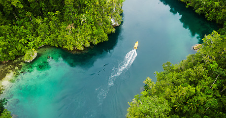 Image showing Island, tropical and drone of a boat in nature with trees for sailing on vacation or weekend trip. Travel, adventure and aerial view of speedboat on a river of resort water for summer holiday.