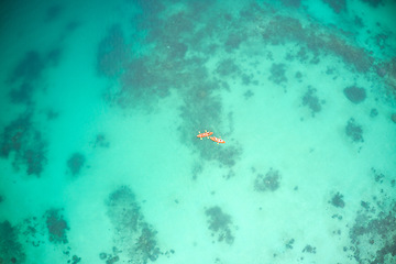 Image showing Top view, boat and people at sea for kayak adventure, travel or journey in ocean together outdoors. Couple traveling, kayaking or rowing on calm, peaceful or serene beach water in natural environment