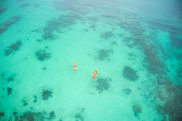 Image showing Aerial boat and people in ocean for kayak adventure, travel or journey at sea together in the outdoors. Couple traveling, kayaking or rowing on big calm, peaceful or serene beach water in nature