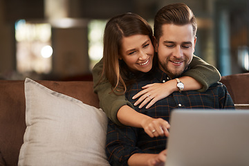 Image showing Relax, laptop and social media with a couple on a sofa in the living room of their home together. Computer, web or internet with a man and woman hugging while bonding in their house on the weekend