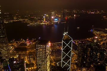 Image showing Night, cityscape and urban skyline by buildings, light or architecture for infrastructure, development or expansion. Dark metro, cbd or city background by skyscraper, road or drone view of Hong Kong