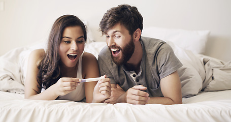 Image showing Happy couple on bed, surprise and pregnancy test, shock and excited for future family, life, love and happiness. Positive results, man with pregnant woman in bedroom and good news in home together.