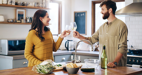 Image showing Happy couple, champagne and cheers in kitchen for anniversary, date or celebration together at home. Man and woman in relationship with alcohol or win for valentines day, love or toast at the house