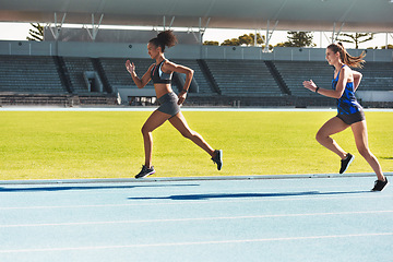 Image showing Woman, running and stadium track for race, competition or fitness athletics in the outdoors. Fit, active or sporty women, runner or sprinting in exercise, workout or training for healthy cardio