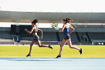 Image showing Woman, running and stadium track in competition, race or fitness for athletics in the outdoors. Fit, active or sporty women, runner or sprinting in exercise, workout or training for healthy cardio