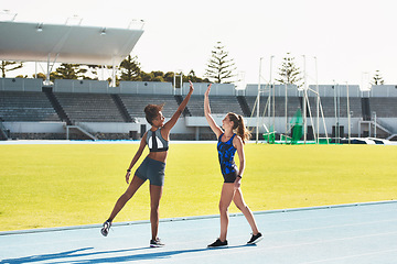 Image showing Woman, team and high five on stadium track for running, exercise or training together in athletics outdoors. Women touching hands in celebration for exercising, run or winning in teamwork and fitness